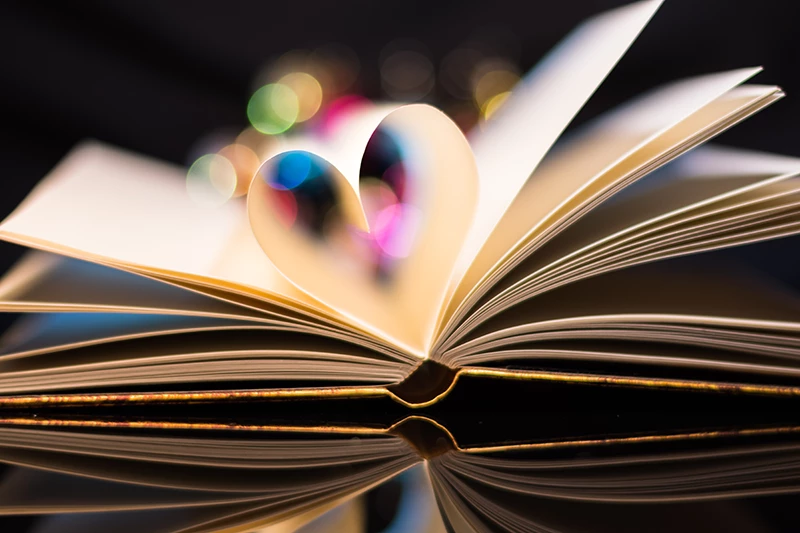 an open book with pages forming a heart shape