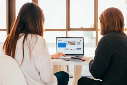 two women looking at a laptop screen